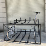 Fixed black two-tier bike rack for 10 bicycles, designed without gas assist, suitable for outdoor or public space installation.