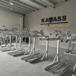 Gas Assist Double Decker Bike Rack, multiple sets arranged neatly in an indoor setting, with red handle grips and the 'KAVASS' logo on the wall.