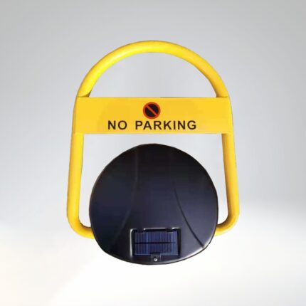 Close-up of solar-powered remote parking lock, showing 'NO PARKING' text and symbol on yellow arm, with black base and solar panel clearly visible.