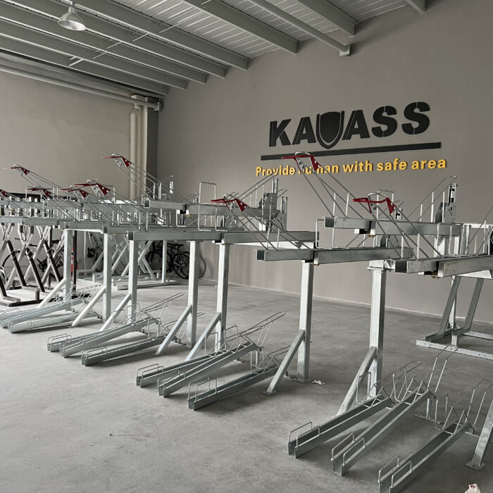 Gas Assist Double Decker Bike Rack, multiple sets arranged neatly in an indoor setting, with red handle grips and the 'KAVASS' logo on the wall.