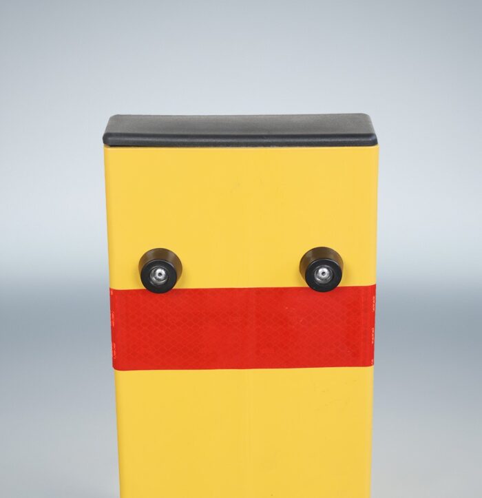 Back-angle close-up of yellow folding bollard’s top section with red reflective strip, focused on enhanced visibility from rear approach.