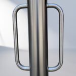 Close-up of the stainless steel handle on the D-type bollard bike rack, showing smooth welding lines and a brushed metal finish.