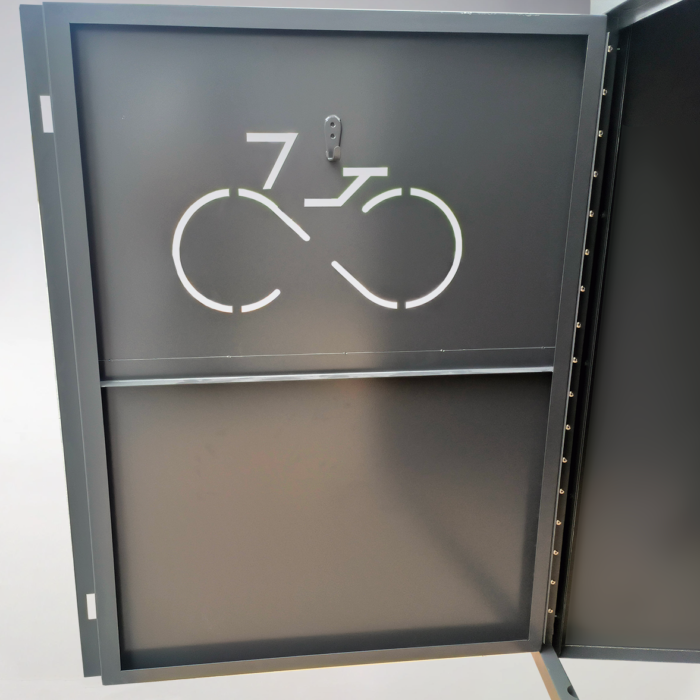 Interior view of a single-door bike locker with reflective bicycle icon on the door for night visibility and organized storage space.