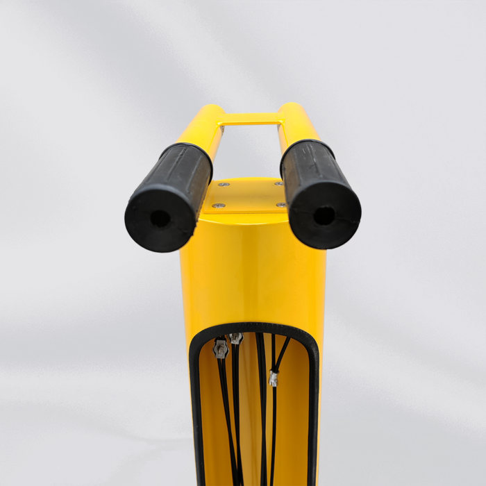 Close-up of the top section of the yellow bicycle repair station, showing black protective parts for handling and tool safety.