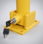 Close-up of yellow fold-down bollard with key-locking mechanism and spring-loaded structure for impact resistance, designed for parking lot safety and vehicle access control.