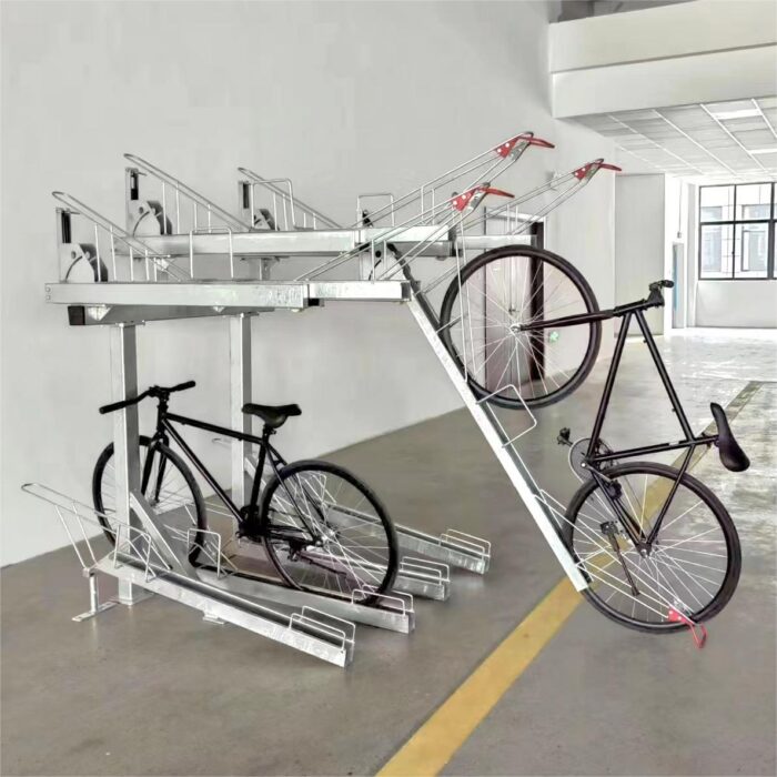 Gas Assist Double Decker Bike Rack with a black bicycle being placed on the upper layer, indoors with yellow floor markings.