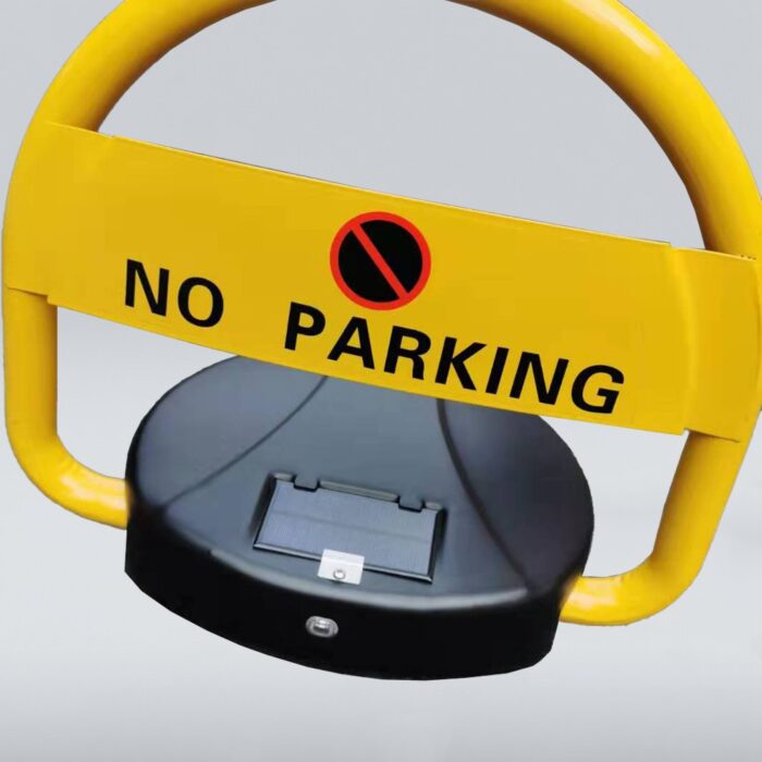 Detailed view of solar-powered parking lock with yellow body and 'NO PARKING' sign. Solar panel on black base prominently visible.