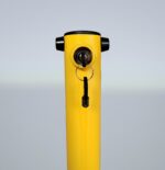 Close-up of built-in lock on yellow fold down bollard, highlighting secure key-inserted locking mechanism for controlled vehicle access.