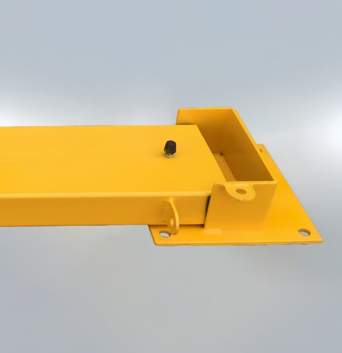 Ground-level view of fold-down parking bollard base with visible lock slot and yellow finish, designed for vehicle access control.