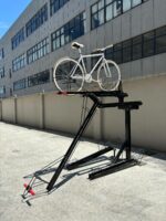 KAVASS dual-assisted bike rack with a white bicycle on the upper tier, illustrating its space-saving two-level design.