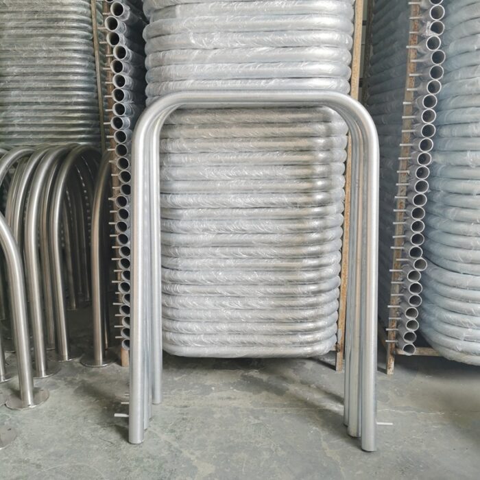 Shiny hot-dip galvanized carbon steel pipes stored in factory warehouse, customizable for U-bar bollard and public facility installations.
