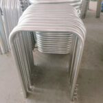 Galvanized in-ground U-bar bollards stacked in warehouse.